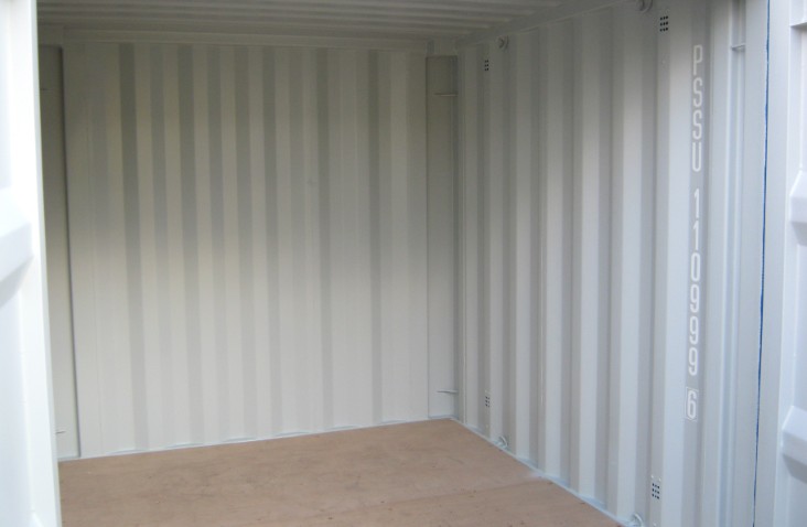 Inside view of an 8ft shipping container with light grey walls and a durable wooden floor