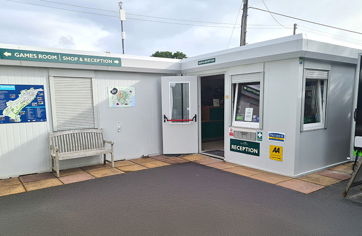 Modular reception unit with signage, shop entrance and customer service area for visitor management at commercial or leisure sites.