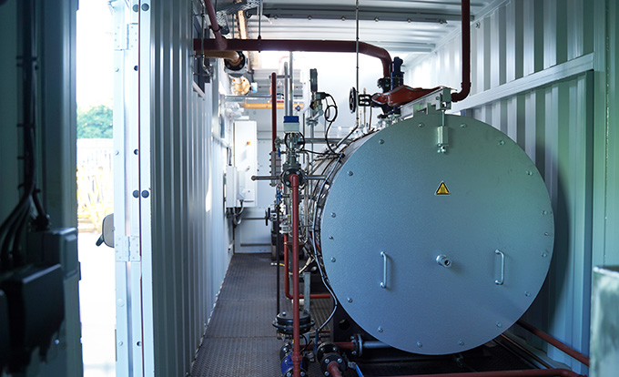 Converted shipping container boiler housing with installed industrial boiler system, engineered by S Jones Containers to provide safe, compliant and portable plant room solutions for commercial and industrial sites in the UK.