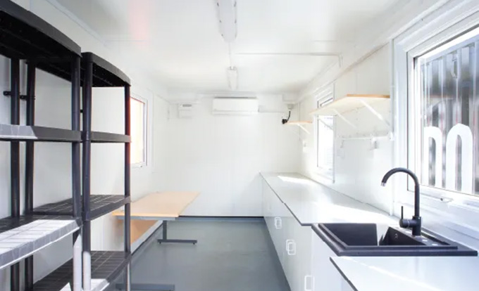 Converted shipping container laboratory by S Jones Containers, fitted with workbenches, sink, storage and lighting to create a secure, compliant and portable lab space for research, testing and scientific applications across the UK.