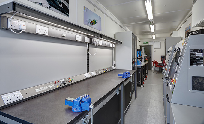 Converted shipping container workshop by S Jones Containers, fitted with workbenches, power sockets, lighting and secure access to provide a durable, portable and fully equipped on-site workspace for fabrication, maintenance and trade use across the UK.