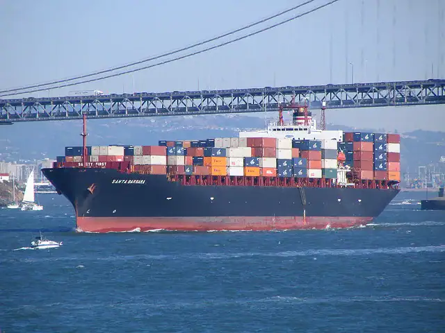 A large shipping boat on the sea stacked with many shipping containers