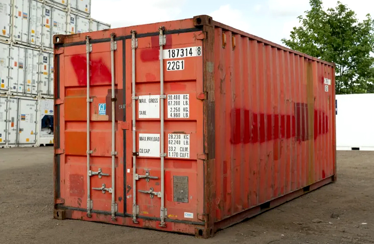 Used red 20ft shipping container for sale, with secure cargo doors and visible wear, suitable for storage or site use. 