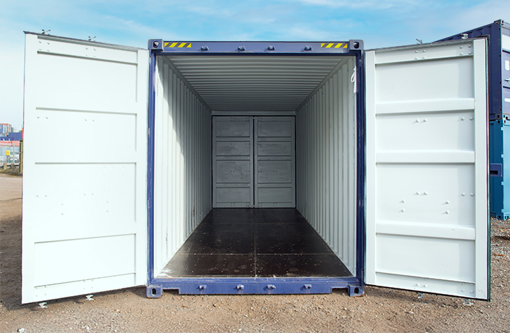 Front view of a blue 20ft high cube shipping container with both sets of doors open, revealing a clean, empty interior and dark plywood flooring on a gravel yard.