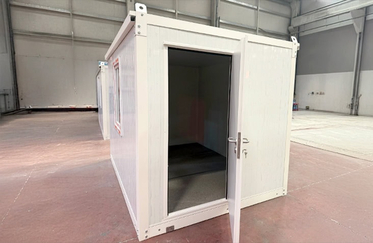 White flat pack office unit with a single open door and side window, shown indoors to display the interior workspace