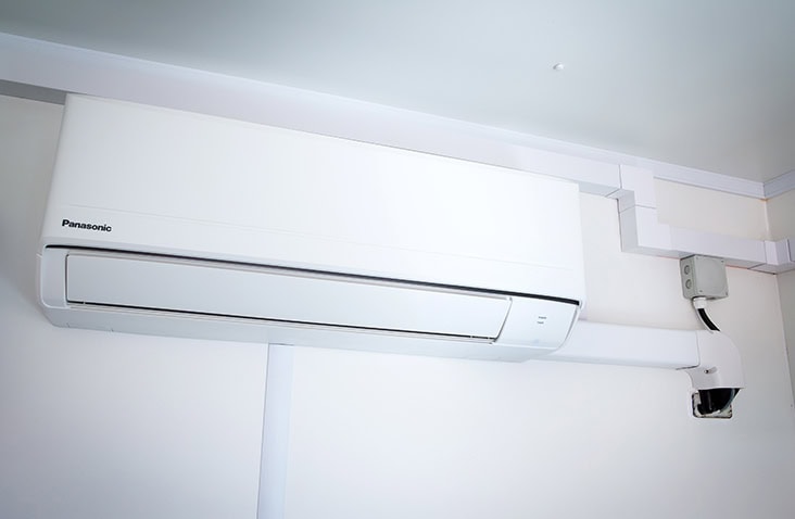 Internal wall-mounted Panasonic air conditioning unit installed inside an insulated shipping container. 
