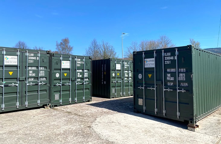 Outdoor self storage facility featuring multiple dark green 20ft S Jones Containers used for container hire, container sales, and secure storage units. 