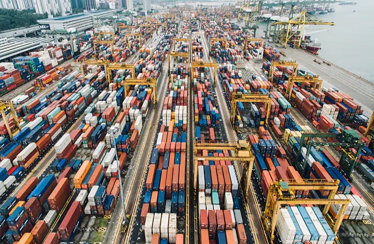 A close up aerial view of a dockyard with rows of shipping containers