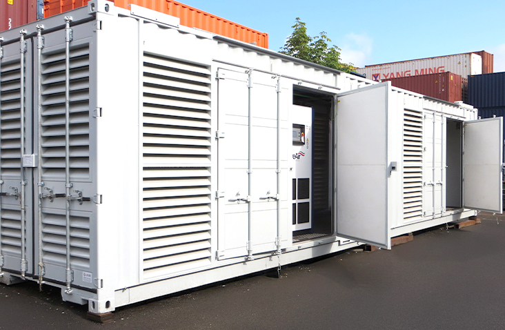 40ft containerised compressor housing with louvred ventilation panels and multiple access doors open, showing internal equipment access points, located on an industrial site. 