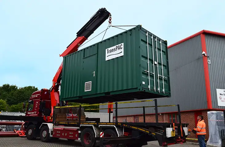A shipping container in the process of placement