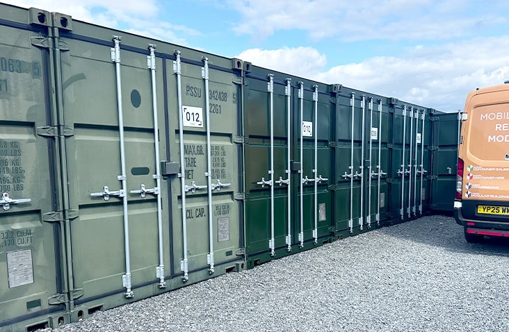Green shipping containers with faded paint alongside a restored container with a deeper, refreshed colour after ClearRestore® treatment.