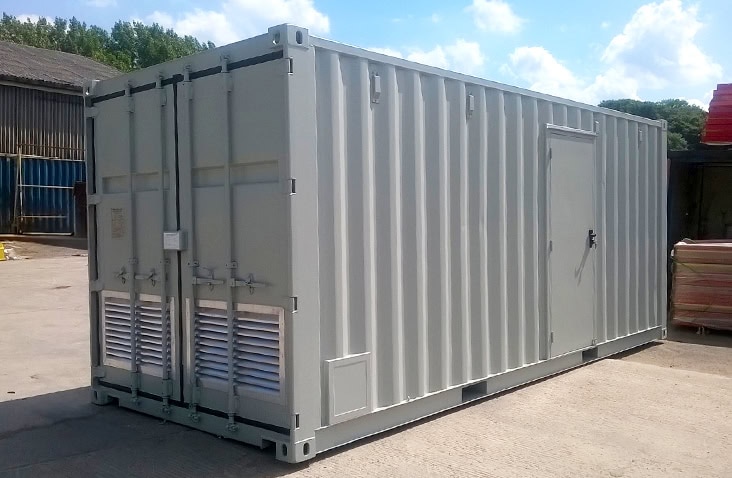 20ft shipping container converted to house an oil boiler, showing a grey containerised boiler room with ventilation louvres, personnel access door and secure structure for plant equipment.