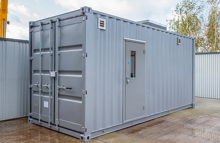 20ft lithium-ion battery storage container, showing a grey converted shipping container with personnel access door, ventilation louvres and secure cargo doors designed for safe battery storage and energy systems.