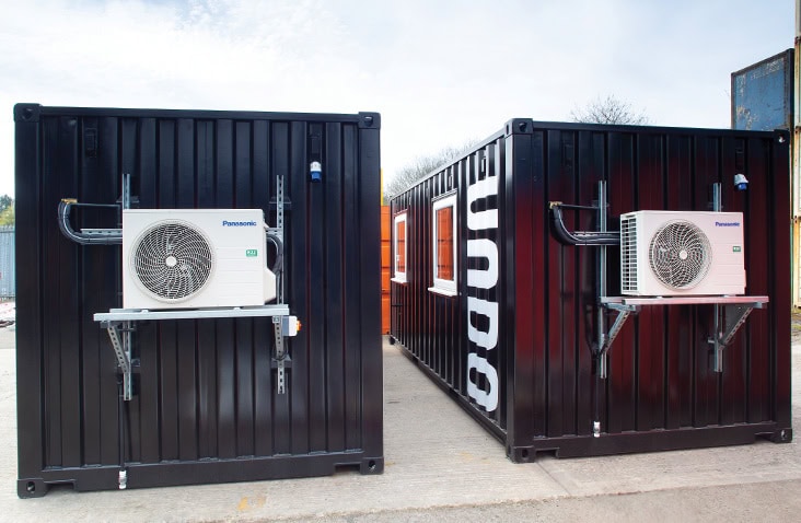 Containerised laboratory with wall-mounted HVAC system, showing external air conditioning units installed on black shipping containers to provide climate control for laboratory use. 
