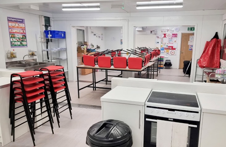 Modular school kitchen and food preparation area, showing fitted appliances, worktops, storage and seating inside a purpose-built modular education facility.