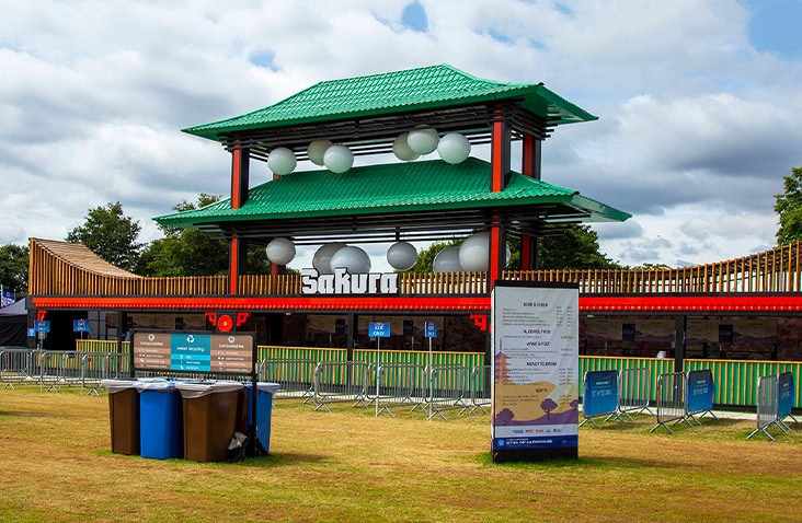 Completed Sakura festival bar constructed from shipping containers, featuring green tiled roof, timber cladding, integrated lighting and signage, demonstrating a bespoke containerised bar and event venue.