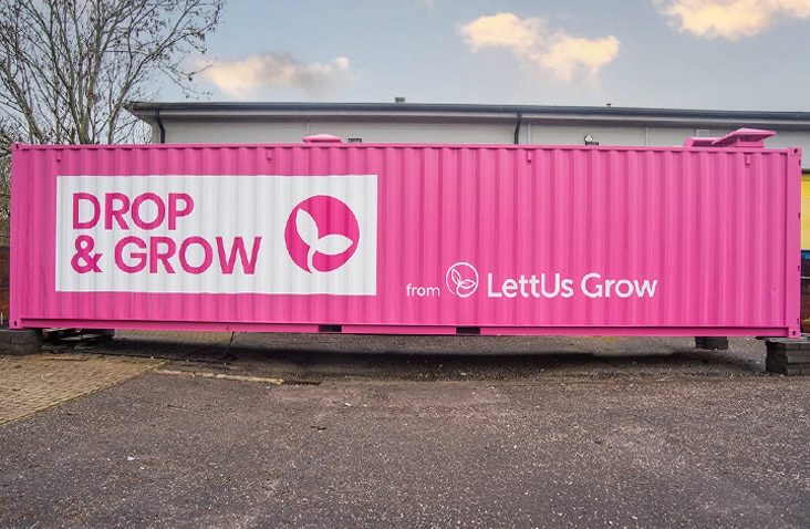 40ft high cube shipping container converted into a vertical farm, showing a pink branded container for the Drop & Grow system by LettUs Grow, designed for controlled environment agriculture.