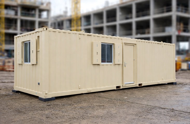     Cream-coloured 32ft steel site accommodation changing room with windows and personnel door, positioned on a construction site to provide workforce welfare facilities including changing, storage and rest areas. 