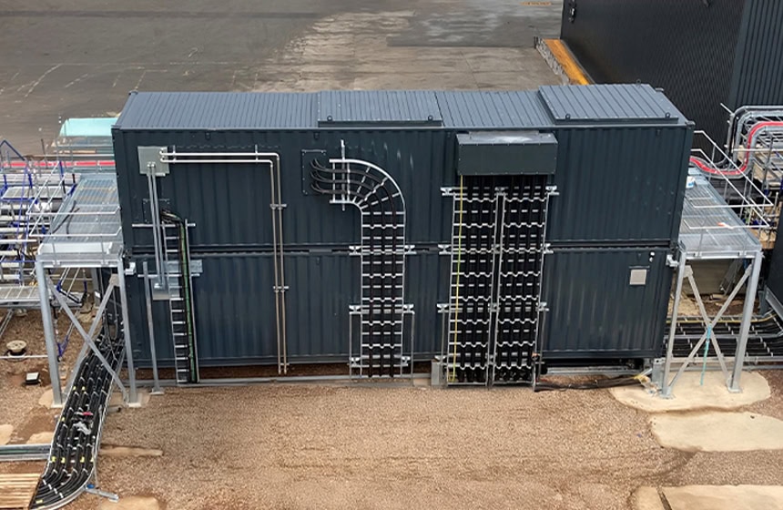 Energy regeneration container enclosure with external cable management, showing a containerised plant room fitted with pipework, electrical cabling, access platforms and structural supports for energy recovery and power system integration.