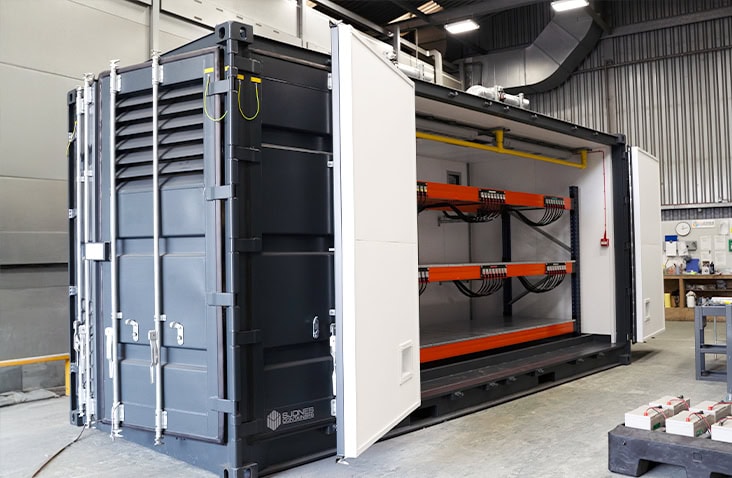 Containerised lead acid battery storage unit with side-opening access, showing internal racking and cable management inside a specialist industrial battery enclosure. 