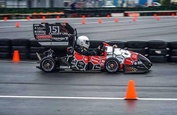 A single-seater racing car from Cardiff University is undergoing track testing on a closed circuit, illustrating high-performance electric vehicle development and battery testing research applications.