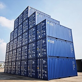 Large stack of new and used blue shipping containers arranged in a depot, ready for sale for storage, construction, or conversion projects.